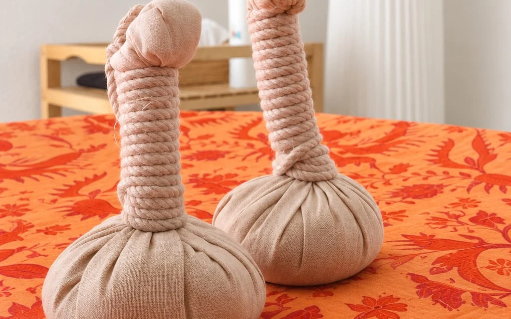 Deux pochons de massage posés sur un tissu orange.