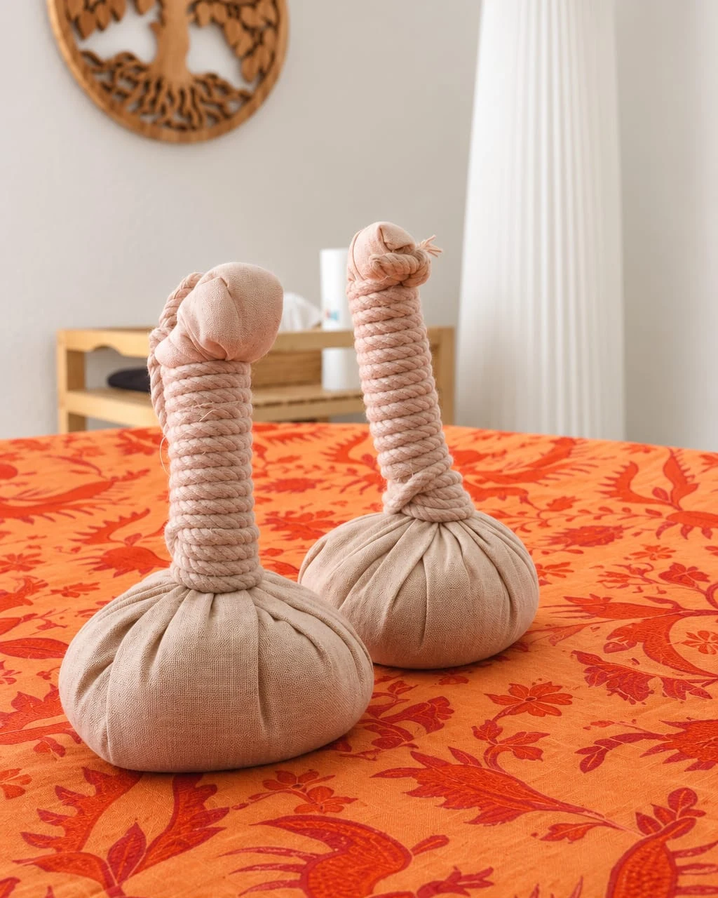 Deux pochons de massage posés sur un tissu orange.